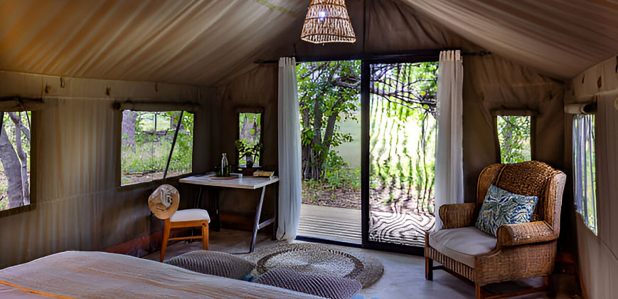 Elegant safari camp bedroom with luxury linens, ambient lighting, and views of the African wilderness – exclusive accommodation with Pizet Safaris